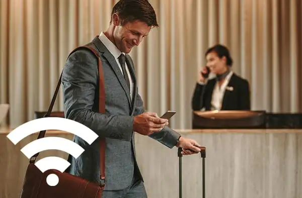 Zakelijke reiziger gebruikt smartphone met wifi in een hotel lobby